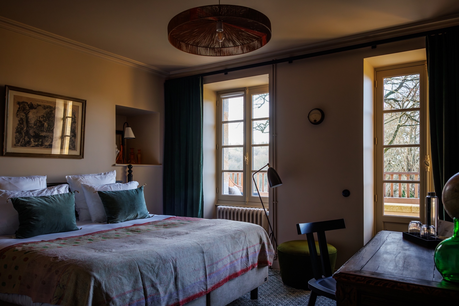 Chambre cosy terrasse mer et sa salle de bain, ses tableaux, son lit et son bureau de bois dans notre hôtel de luxe en bretagne