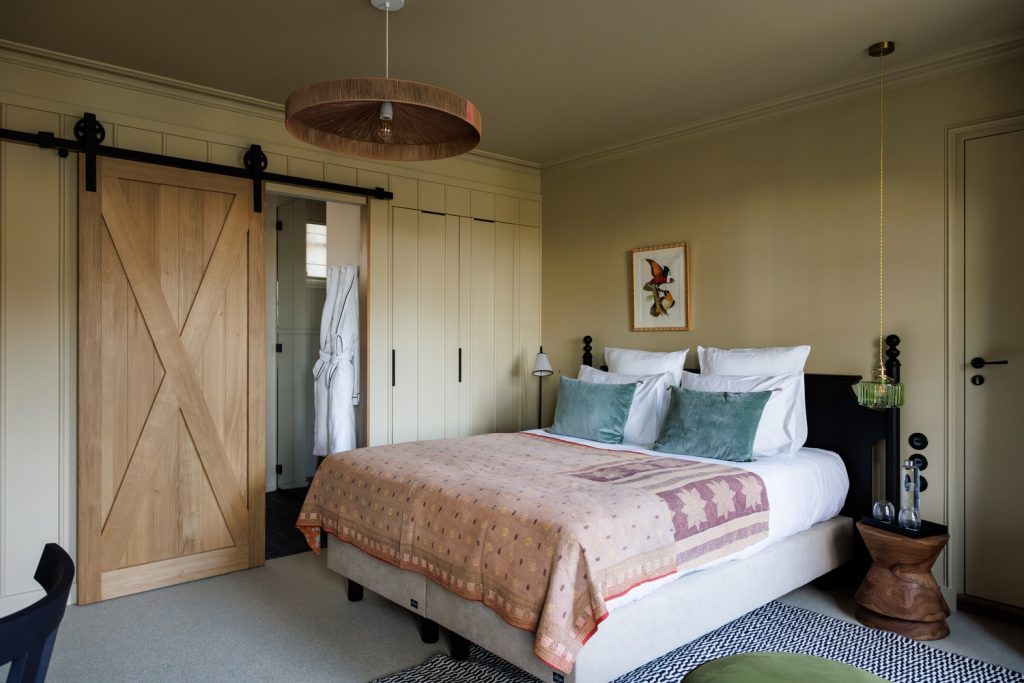 Deluxe room with sea view and bathroom, paintings, bed and wooden desk in our luxury hotel in Brittany