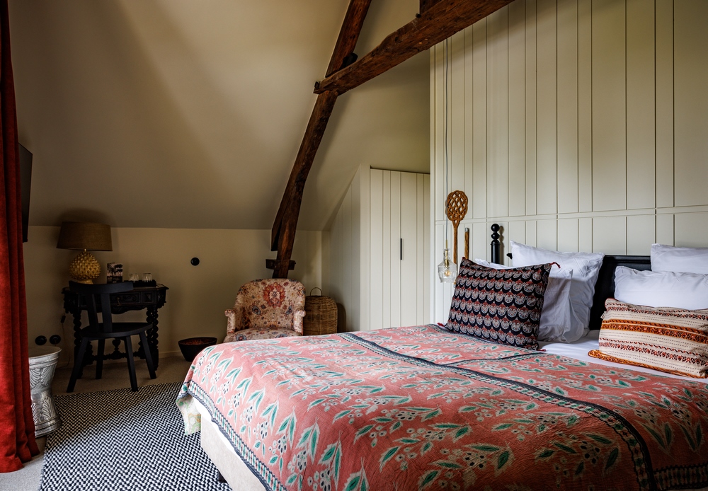 Literie fleurie et colorée et et fauteuil à motif fleuri dans notre hôtel de luxe en bretagne