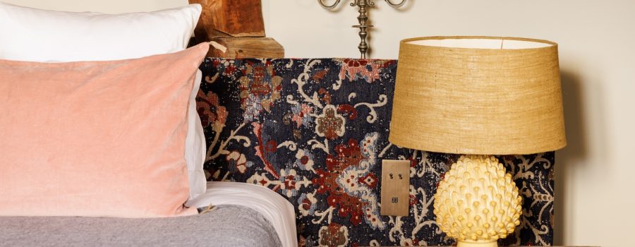 Habitación parque de lujo en el castillo locguénolé con cabecero floral, vigas y muebles de madera