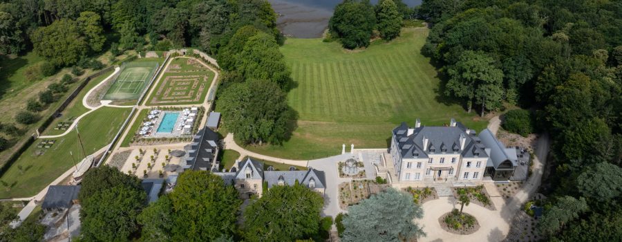 A drone view of the Domaine de Locguénolé with a view of the Blavet, the tennis court, the swimming pool and the forest.