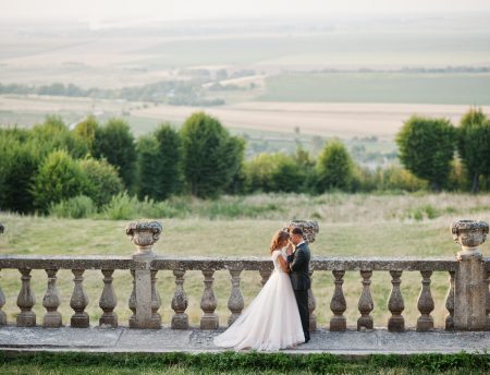 Fabulous wedding couple walking around the castle territory on their festive day.